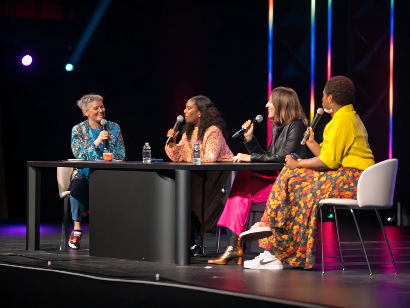 A photograph of a panel discussion at a fashion conference, featuring industry experts sharing insights and engaging with the audience.